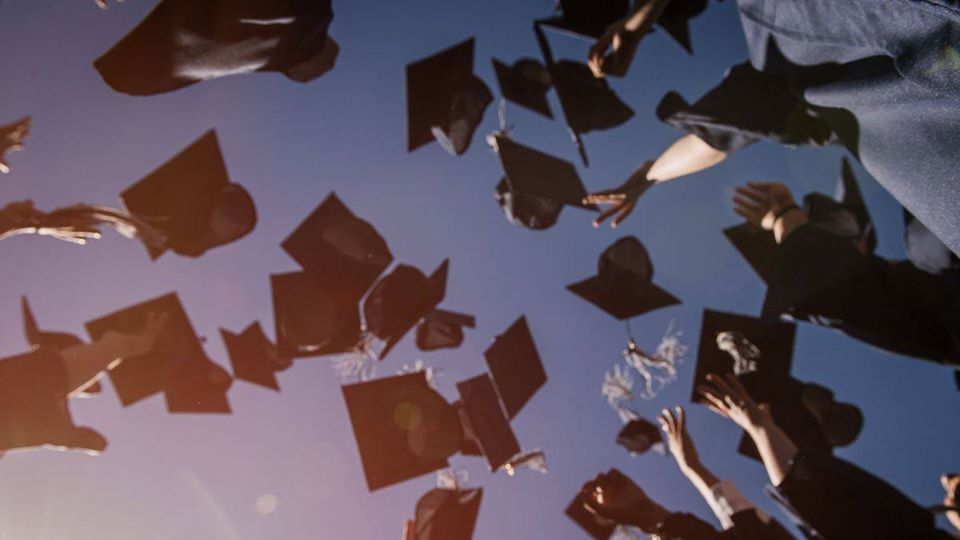 Graduate mortarboards tossed into the sky